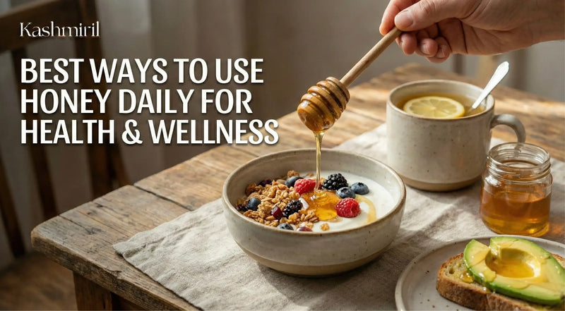 Featuring Image for Best Ways To Use Honey For Health and Wellness and Person drizzling honey over a bowl of yogurt with granola and berries on a wooden table.