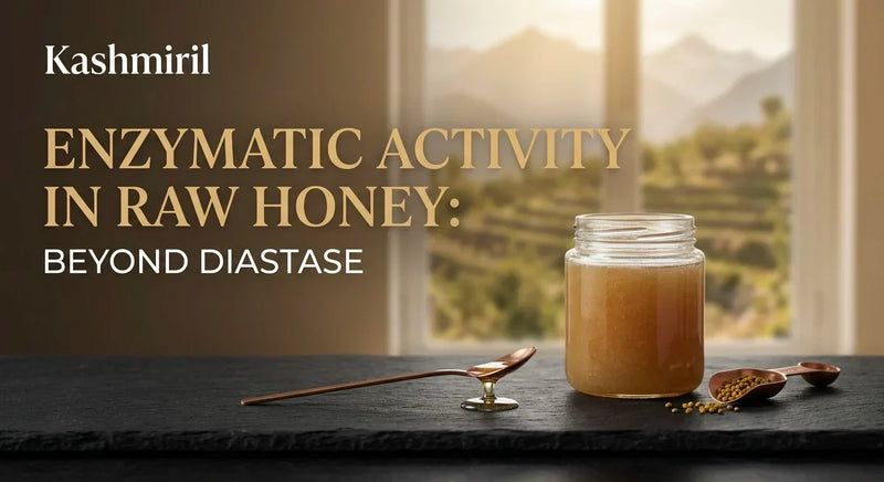 Kashmiril - ENZYMATIC ACTIVITY IN RAW HONEY: BEYOND DIASTASE. Glass jar of raw honey with copper spoons and pollen on dark slate against scenic mountain window view.