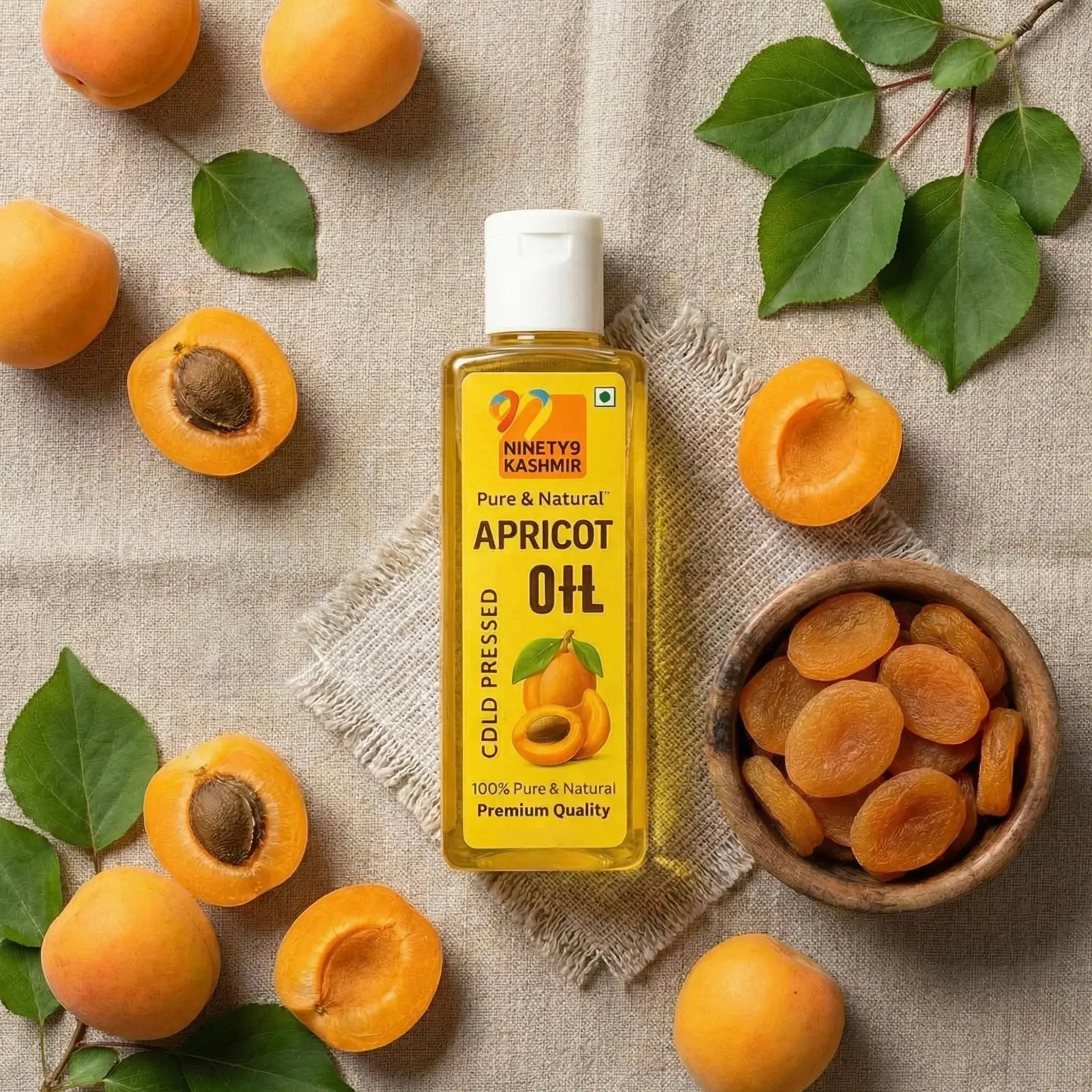 Kashmiril Apricot Oil bottle surrounded by apricots on a textured fabric background