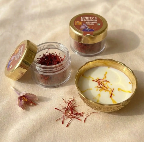 Jars of saffron and a bowl with saffron strands on a beige surface