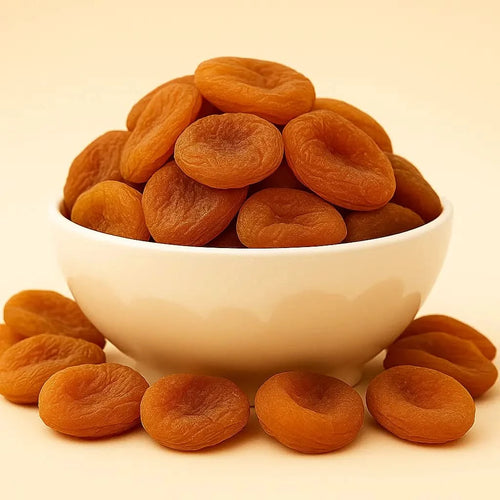 White bowl filled with dried apricots on a beige background