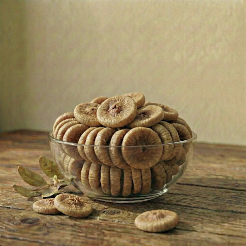 White bowl filled with dried figs on a beige background