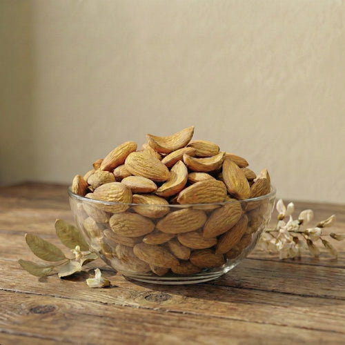 White bowl filled with Mamra almonds on a beige background