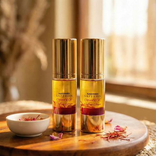 Two Kashmiri Saffron Serum bottles on a wooden table with saffron strands and a bowl.