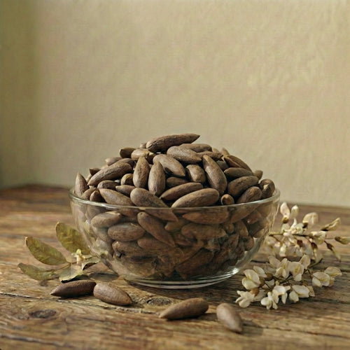 White bowl filled with Pine Nuts on a beige background