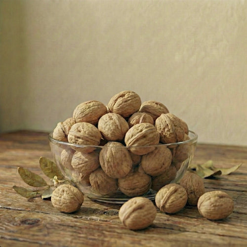 White bowl filled with walnuts on a beige background